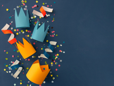 Birthday party hats and confetti on a blue background