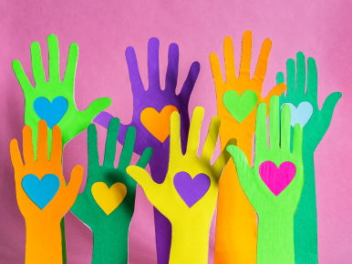 Hands with hearts in the palms on a pink background