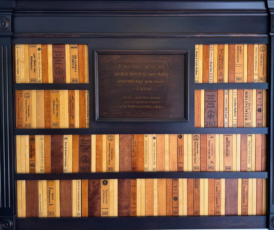 Wall with wooden book spines that have donors names engraved on them.