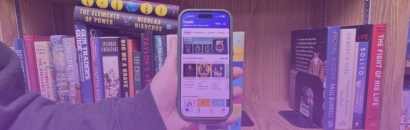 Person holding phone in front of book shelf